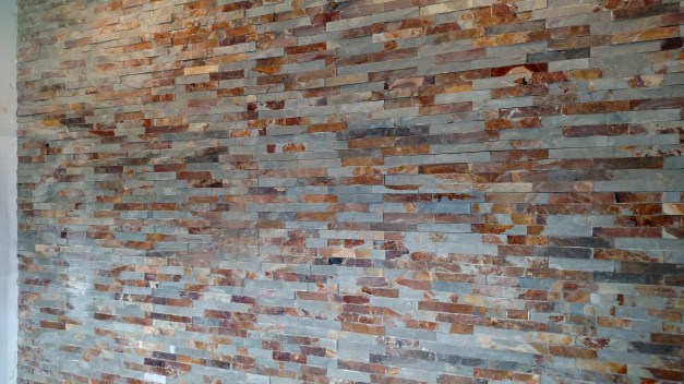 In the foyer, this is the entry way wall of tile, mimics the stone on the exterior. 